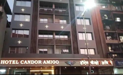 a building with a hotel cardier amoco in front of it at Hotel Candor Amigo Kamothe Panvel in Navi Mumbai