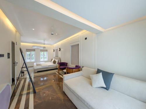 a living room with a white couch in a room at Finca - the tidal nest in Candolim