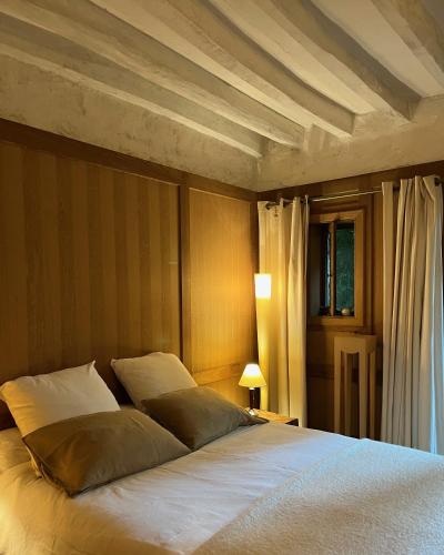 ein Schlafzimmer mit einem großen Bett und einer Holzdecke in der Unterkunft DIMANCHEVILLE in Dimancheville