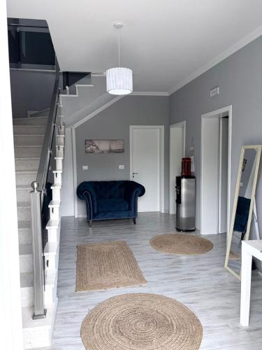 a living room with a blue couch and stairs at Vila 007 in Velipojë