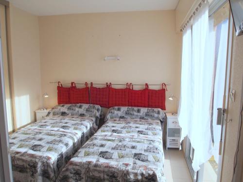 a bedroom with two beds and a red curtain at Appartement Soleil d'Oc 5 in Cazaubon