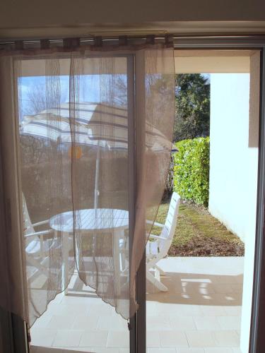a sliding glass door with a table and chairs outside at Appartement Soleil d'Oc 5 in Cazaubon