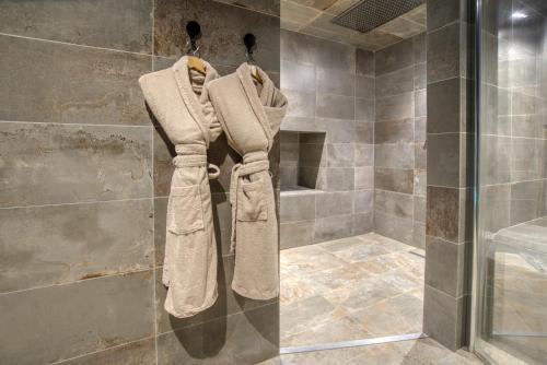 a shower with towels hanging on a wall in a bathroom at SUITE TESORO climatisée avec piscine spa hammam et jardin avec piscine in Saint-Martial-sur-Né