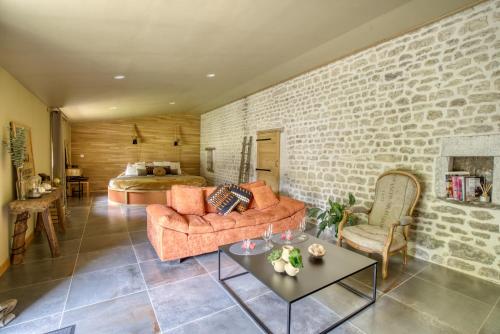 a living room with a couch and a bedroom at SUITE TESORO climatisée avec piscine spa hammam et jardin avec piscine in Saint-Martial-sur-Né