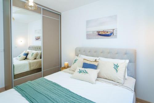 a bedroom with a bed with a mirror at Apartments with Pool 5 Min Walk to Beach in Igalo