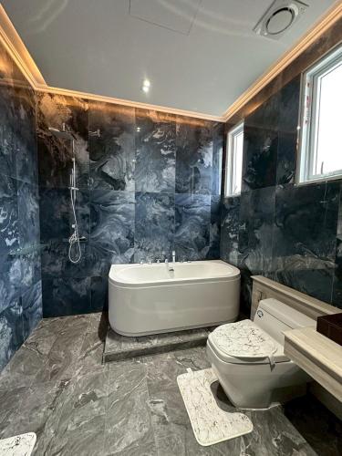 a bathroom with a tub and a toilet and a sink at IP on HOME 1 in Jomtien Beach