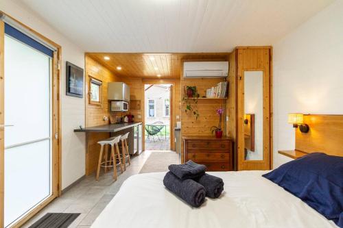 a bedroom with a bed and a kitchen at Tiny House de Charme & Oasis Privée in Toulouse
