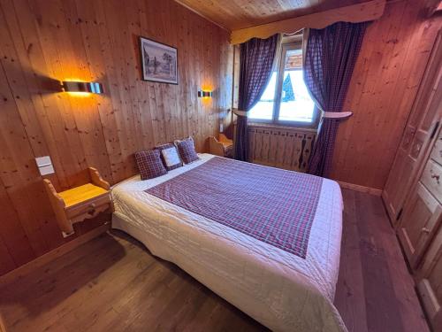 a bedroom with a bed in a wooden room at La chambre Chez Marion 2 personnes in Notre-Dame-de-Bellecombe