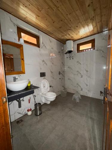 a bathroom with a sink and a toilet at Harshil View Home Stay in Harsil