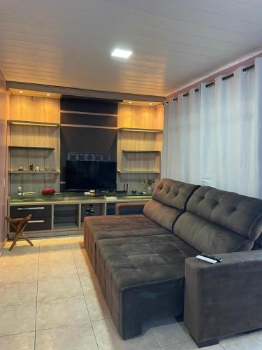 a living room with a couch and a table at Ótima casa 3 quartos, piscina, bem localizada in Foz do Iguaçu
