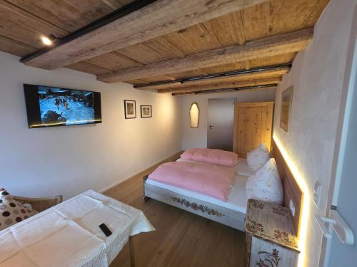a bedroom with a bed and a tv on the wall at Pension Kaiserhaus in Ühlingen-Birkendorf