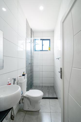 a white bathroom with a toilet and a sink at Nyali luxe 1 bedroom in Nyali