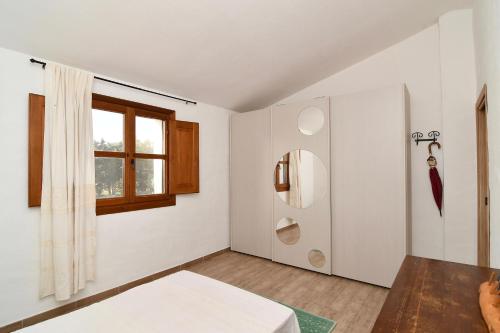 a white room with a bed and a window at Stazzo La Chèa in Nuragheddu
