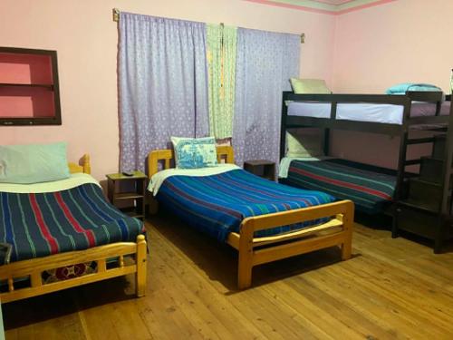 a room with two beds and a bunk bed at Imperio Carlos V in Oruro
