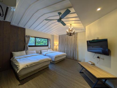 a bedroom with two beds and a ceiling fan at 羅東夏林5號 in Luodong