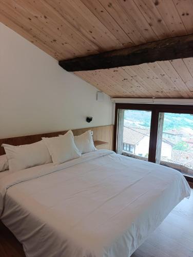 a large white bed in a room with a window at Benaki 99 in Ladines
