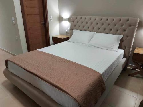 a bedroom with a large bed with a large headboard at K & A Studios 2 in Nydri
