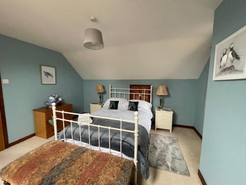 a bedroom with a bed and blue walls at Priory Stream, Lower Priory, Pembrokeshire in Milford Haven