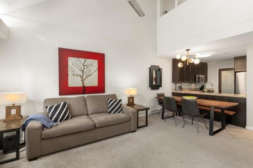 a living room with a couch and a dining room at Glacier Lodge in Whistler