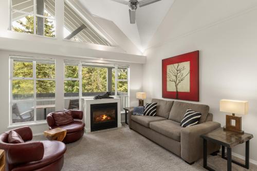 a living room with a couch and a fireplace at Glacier Lodge in Whistler