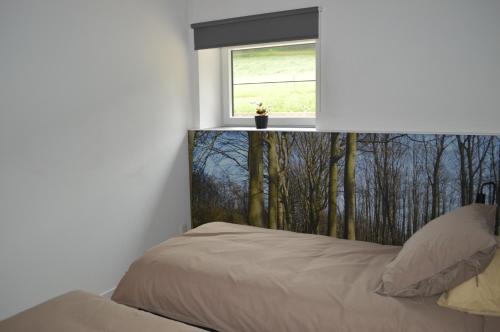 a bedroom with a bed and a window at Vakantie Hermansheuvel in Bekkevoort