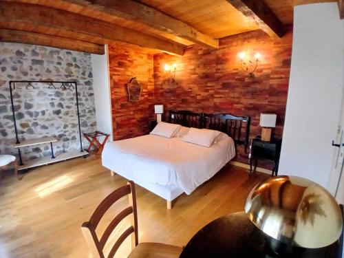 a bedroom with a bed and a wooden wall at Le Coudi in Saint-Pierre-le-Chastel