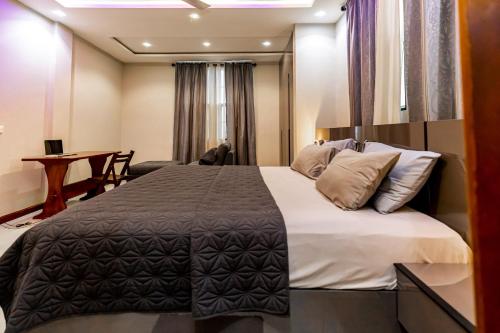 a bedroom with a large bed and a desk at Davina's Villa in Kumasi