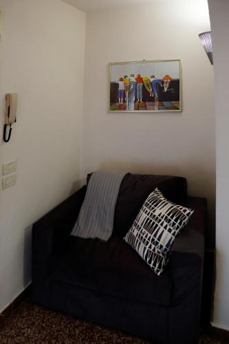 a black couch in a room with a picture on the wall at Appartamento La Casina in Pistoia