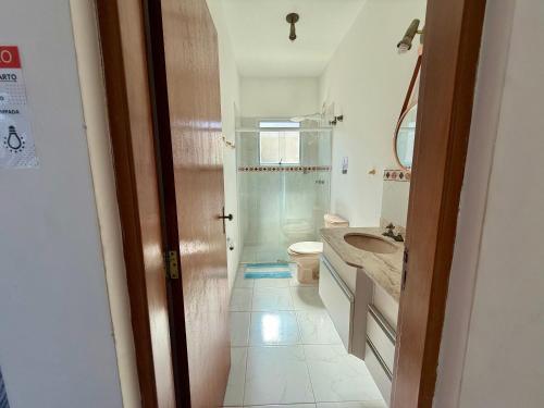 a bathroom with a shower and a toilet and a sink at Casa virgínia enseada in Guarujá