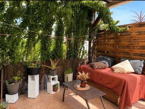 a patio with two beds and potted plants at Maisonette in Saint-Raphaël