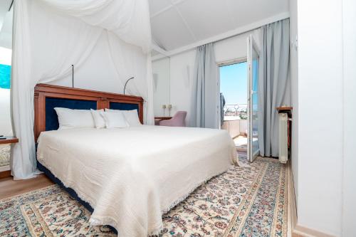 a bedroom with a white bed and a large window at Captain's Escape - Spa City View in Mali Lošinj