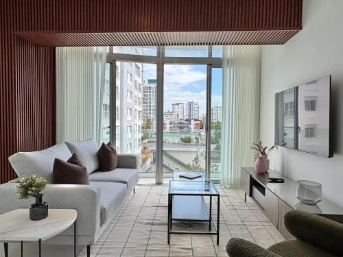 a living room with a couch and a large window at Shalom Suites by Yellowkey in Santo Domingo