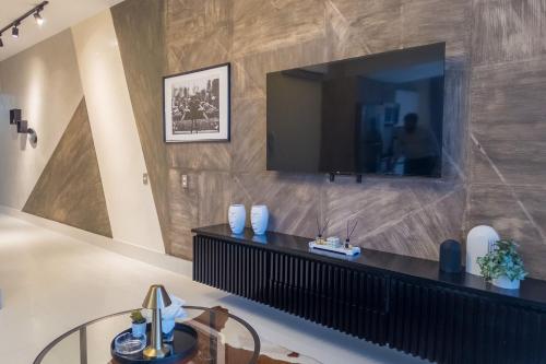 a living room with a television on a wall at Shalom Suites by Yellowkey in Santo Domingo