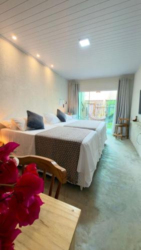 a hotel room with two beds and a table at VILA GAHERI Pousada Boutique com Piscina Privativa in São Miguel dos Milagres