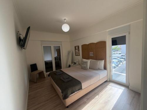 a bedroom with a large bed and a balcony at Feel Like Your Home in Montijo