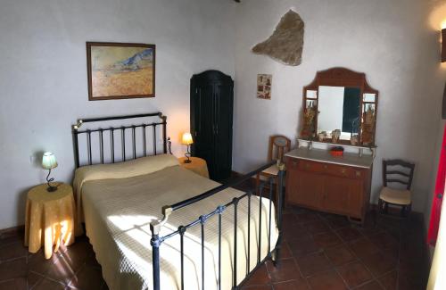 a bedroom with a bed and a dresser and a mirror at Cortijo Viña del Duco in Azuaga