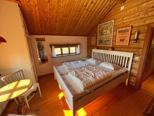 a bedroom with a bed in a log cabin at Lake Lodge Rönnäs in Leksand