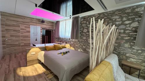 a bedroom with a bed and a stone wall at Suite spa civico 4 in Follonica