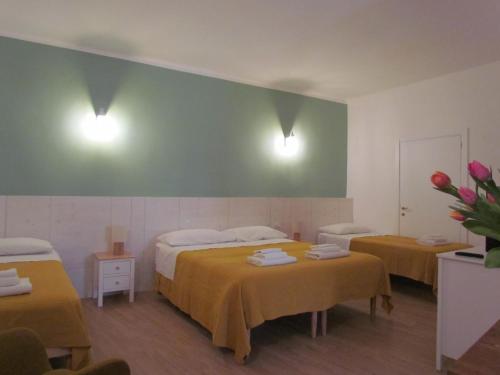a hotel room with two beds and two tables at Arco Michele in Putignano