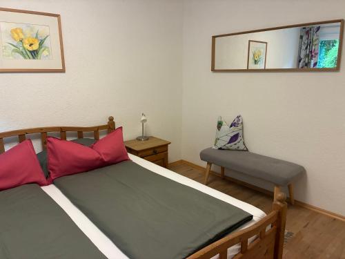 a bedroom with a bed with red pillows and a mirror at Garten Apartment Diwoky in Sankt Gilgen