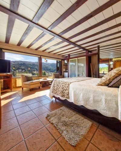a bedroom with a bed and a large window at Suites de la Colina in La Cumbrecita