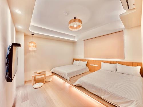 a bedroom with two beds and a flat screen tv at 初見庭野 in Ch'ing-shui