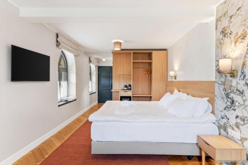 a bedroom with a large white bed and a tv at Dokia Boutique in Gura Humorului