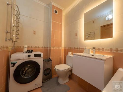 a bathroom with a washing machine and a toilet at RentHouse Apartments Metropolis in Chişinău