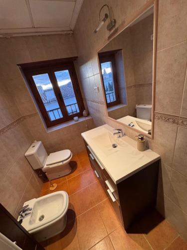 a bathroom with a sink and a toilet and a mirror at Raíces del Noroeste in Caravaca de la Cruz