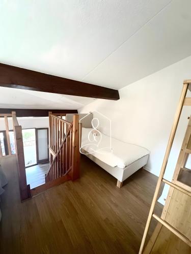 a living room with a bed and a staircase at La Petite Provence in Tourrettes