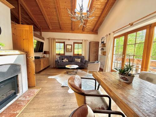 a living room with a fireplace and a table and chairs at CHALET BELLE KITZ by Belle Stay in Kitzbühel
