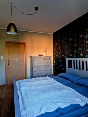 a bedroom with a large bed and a dresser at Elbsandstein vor der Tür in Lohmen