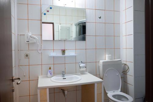 a bathroom with a sink and a toilet and a mirror at Occidental Wise Transit in Bucharest