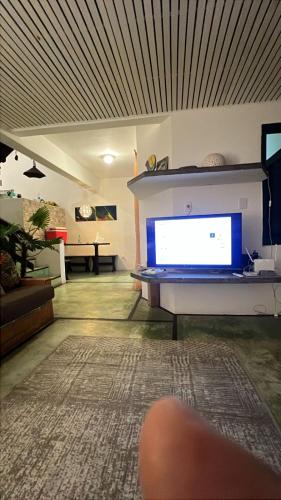 a living room with a large computer monitor on a table at Delba Costa Smeralda - Barra do Una in Barra do Una